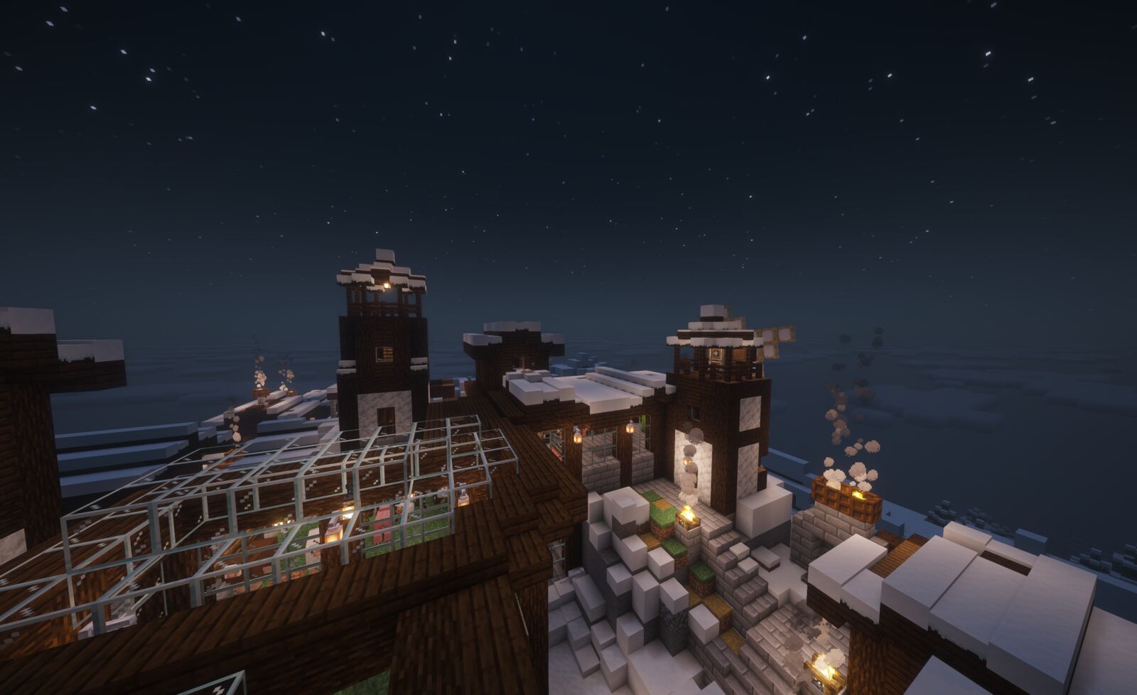 The Tree SMP spawn village at night: lit windows, a glass greenhouse and snow-topped towers under a starry sky.